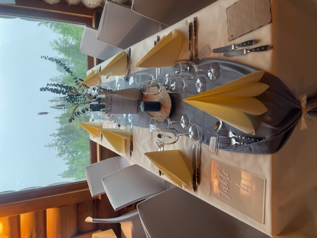 tables dressées dans le restaurant Le Poyet Aux Rousses avec une ambiance bois et vue sur l'extérieur boisée