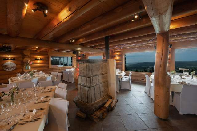 tables dressées dans le restaurant Le Poyet Aux Rousses avec une ambiance bois etvue sur l'extérieur boisée